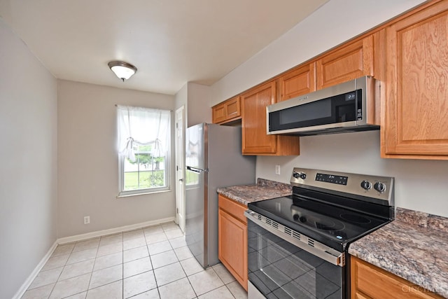 5 Spotswood Cmn, Union Twp, OH 45103 - kitchen featuring appliances with stainless steel finishes, baseboards, light tile patterned floors, and dark stone countertops