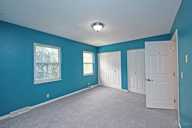 5 Spotswood Cmn, Union Twp, OH 45103 - unfurnished bedroom featuring multiple closets, carpet, baseboards, and a textured ceiling