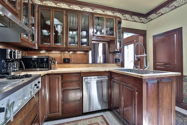2334 Upland Pl, Cincinnati, OH 45206 - kitchen with appliances with stainless steel finishes, exhaust hood, light countertops, a peninsula, and glass insert cabinets