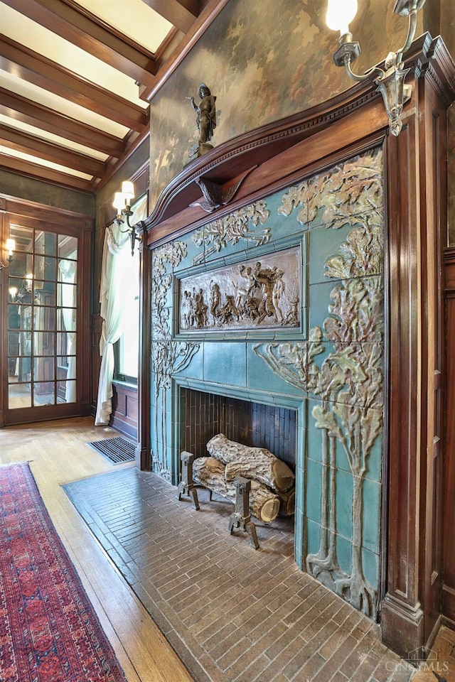 2334 Upland Pl, Cincinnati, OH 45206 - detailed view of a tiled fireplace, beam ceiling, wood finished floors, and a chandelier