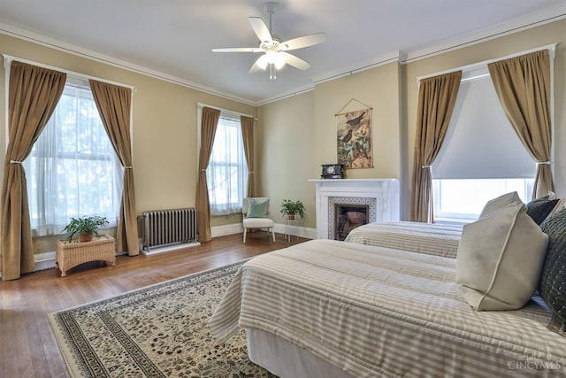 2334 Upland Pl, Cincinnati, OH 45206 - bedroom with radiator heating unit, wood finished floors, ornamental molding, a tiled fireplace, and a ceiling fan