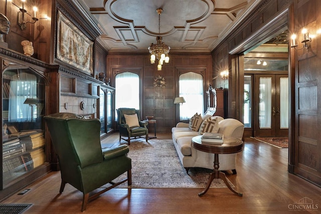 2334 Upland Pl, Cincinnati, OH 45206 - living room featuring crown molding, wooden walls, a chandelier, and wood finished floors