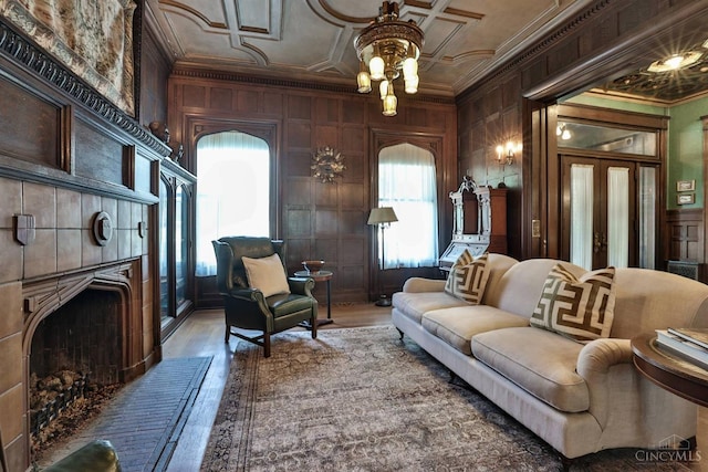 2334 Upland Pl, Cincinnati, OH 45206 - living area with crown molding, a tiled fireplace, wood finished floors, and wooden walls