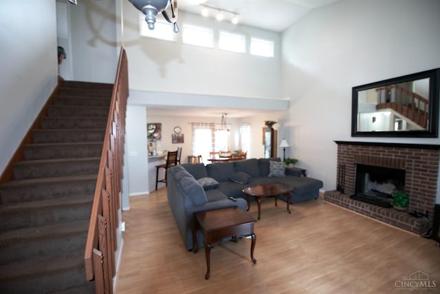 4840 Shannon Way, Middletown, OH 45042 - living room featuring high vaulted ceiling, stairs, healthy amount of natural light, wood finished floors, and a brick fireplace