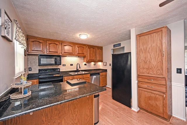 2868 Grosvenor Dr, Colerain Twp, OH 45251 - kitchen with black appliances, a sink, brown cabinetry, light wood-style flooring, and a textured ceiling