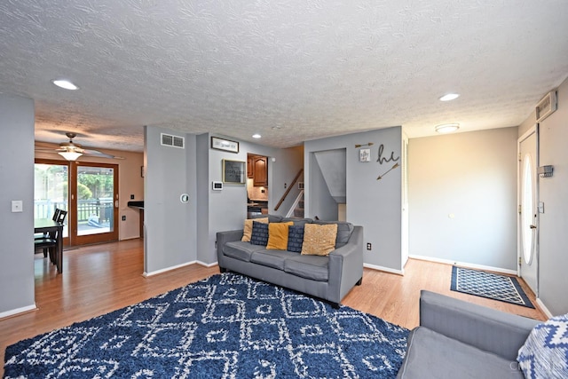 2868 Grosvenor Dr, Colerain Twp, OH 45251 - living area with light wood-style floors, a textured ceiling, baseboards, stairs, and ceiling fan