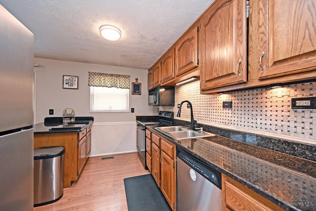 2868 Grosvenor Dr, Colerain Twp, OH 45251 - kitchen with black appliances, a sink, light wood-style floors, brown cabinets, and a wainscoted wall