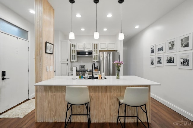983 Paradrome St Unit A, Cincinnati, OH 45202 - kitchen featuring appliances with stainless steel finishes, a sink, dark wood-style floors, a breakfast bar area, and recessed lighting