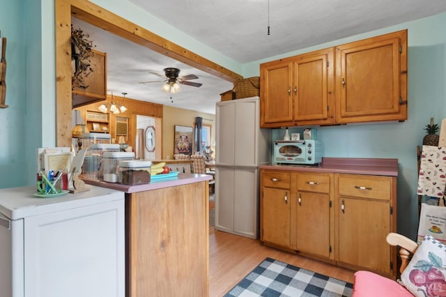 12977 E US Rt 50, Paint Twp, OH 45612 - kitchen featuring light wood-style flooring, ceiling fan, brown cabinets, and light countertops