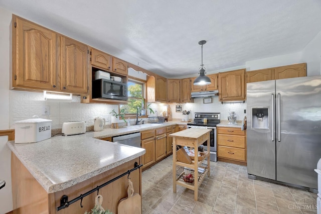 55 Kastrup Dr, Lakengren, OH 45320 - kitchen with appliances with stainless steel finishes, under cabinet range hood, a sink, light countertops, and decorative backsplash