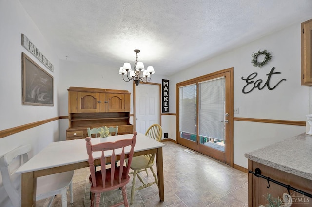 55 Kastrup Dr, Lakengren, OH 45320 - dining room featuring a chandelier, baseboards, and a textured ceiling