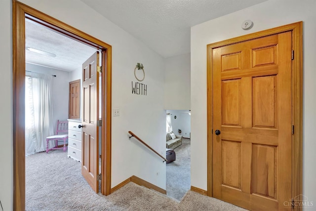55 Kastrup Dr, Lakengren, OH 45320 - hall with carpet, an upstairs landing, a textured ceiling, and baseboards