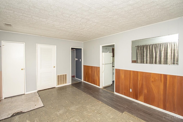 800 Richardson Dr, Middletown, OH 45042 - spare room with parquet flooring, ornamental molding, wooden walls, a wainscoted wall, and a textured ceiling