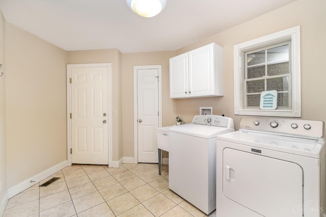 3190 Fox Run Dr, Ross Twp, OH 45013 - laundry area with cabinet space, washer and clothes dryer, and light tile patterned floors