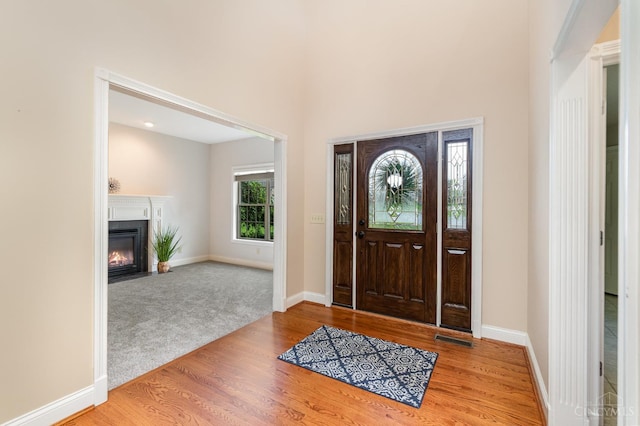 3190 Fox Run Dr, Ross Twp, OH 45013 - entryway featuring wood finished floors, a fireplace with flush hearth, and carpet