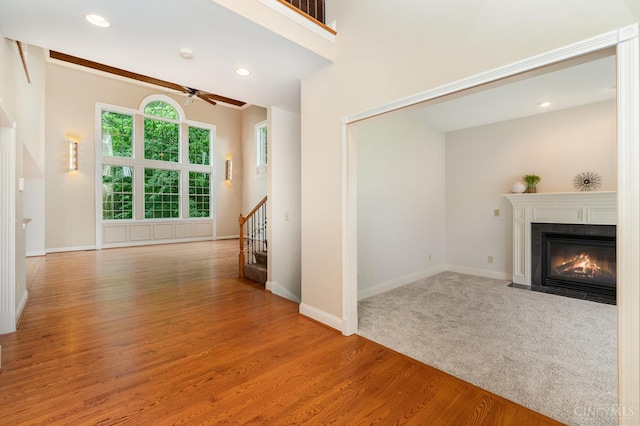 3190 Fox Run Dr, Ross Twp, OH 45013 - unfurnished living room featuring a ceiling fan, a fireplace with flush hearth, light wood-style flooring, stairs, and recessed lighting