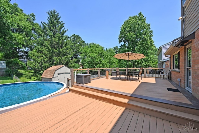 3430 Melodymanor Dr, Colerain Twp, OH 45239 - wooden terrace featuring outdoor dining space, an outdoor pool, and a storage shed