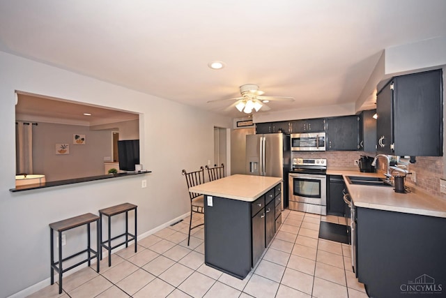 3430 Melodymanor Dr, Colerain Twp, OH 45239 - kitchen with appliances with stainless steel finishes, a kitchen bar, light countertops, ceiling fan, and backsplash