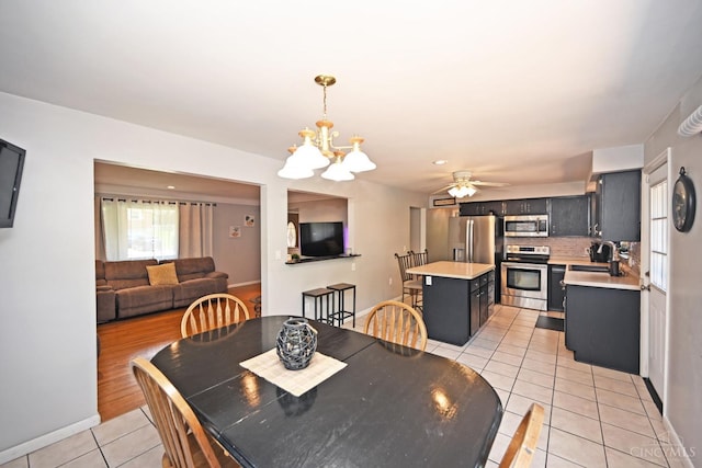 3430 Melodymanor Dr, Colerain Twp, OH 45239 - dining room with light tile patterned flooring, a chandelier, and a ceiling fan