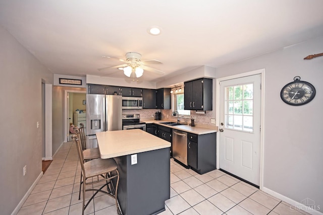 3430 Melodymanor Dr, Colerain Twp, OH 45239 - kitchen featuring appliances with stainless steel finishes, light tile patterned floors, light countertops, a ceiling fan, and a breakfast bar