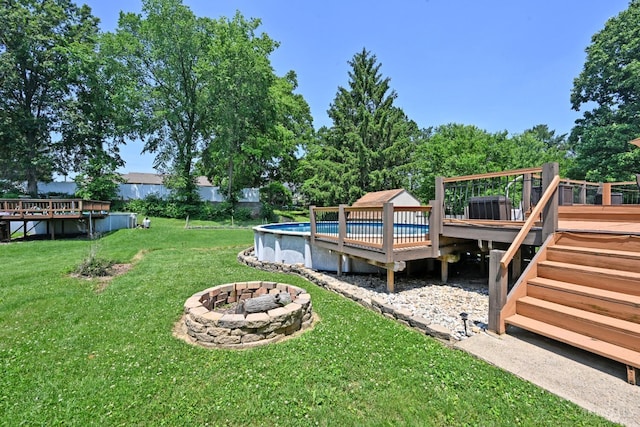 3430 Melodymanor Dr, Colerain Twp, OH 45239 - view of grassy yard with a wooden deck, an outdoor pool, and a fire pit