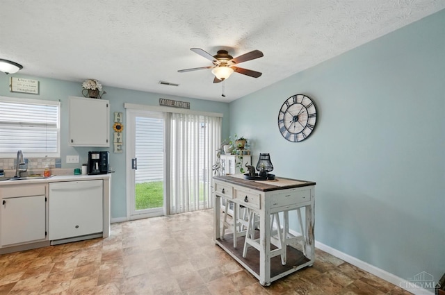 5711 Clemens Dr, Goshen Twp, OH 45140 - kitchen with white dishwasher, a sink, ceiling fan, plenty of natural light, and a textured ceiling