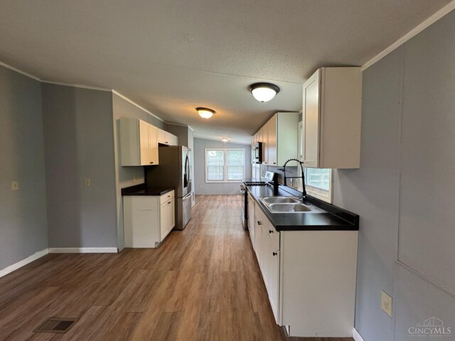46 Frazier Rd, Jefferson Twp, OH 45148 - kitchen with stainless steel appliances, a sink, dark countertops, ornamental molding, and light wood-style floors