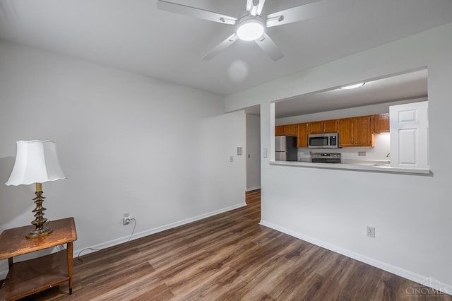 3721 W Galbraith Rd Unit A-2, Cincinnati, OH 45247 - kitchen with appliances with stainless steel finishes, dark wood finished floors, brown cabinetry, baseboards, and a ceiling fan