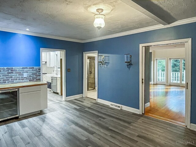 1588 Moon Valley Ln, Anderson Twp, OH 45230 - unfurnished living room with wine cooler, wood finished floors, crown molding, and a textured ceiling