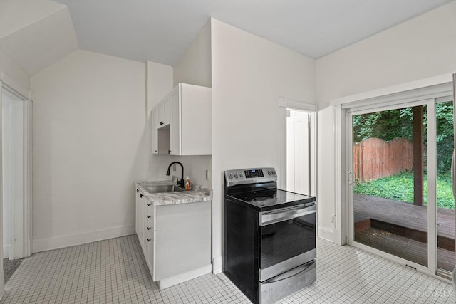 2266 Loth St, Cincinnati, OH 45219 - kitchen with stainless steel range with electric cooktop, light countertops, white cabinetry, and light tile patterned floors