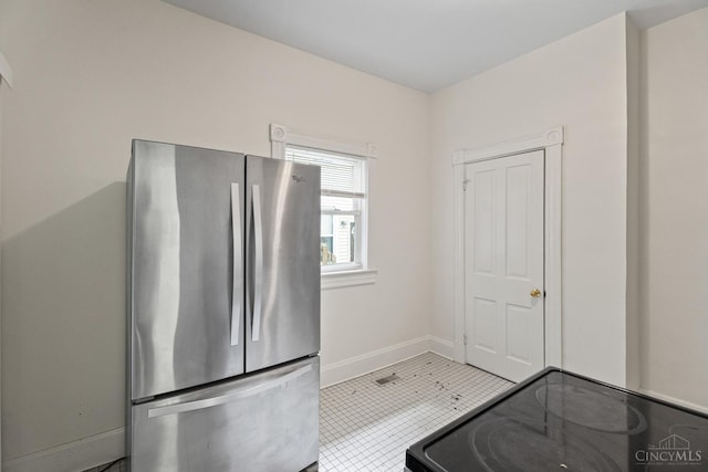 2266 Loth St, Cincinnati, OH 45219 - kitchen featuring freestanding refrigerator, light tile patterned floors, and range