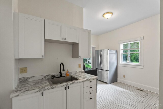 2266 Loth St, Cincinnati, OH 45219 - kitchen featuring freestanding refrigerator, white cabinets, and light stone counters