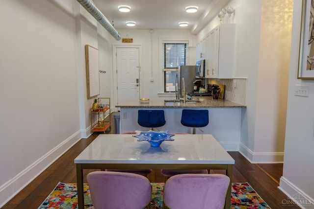 306 Mulberry St Unit 2, Cincinnati, OH 45202 - kitchen featuring stainless steel microwave, white cabinets, dark wood-style flooring, and stone countertops