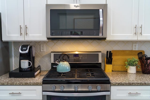 306 Mulberry St Unit 2, Cincinnati, OH 45202 - kitchen featuring appliances with stainless steel finishes, white cabinetry, decorative backsplash, and stone countertops