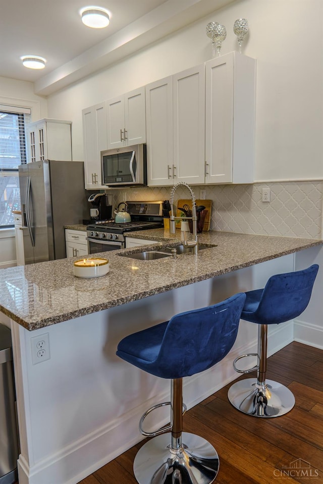 306 Mulberry St Unit 2, Cincinnati, OH 45202 - kitchen with appliances with stainless steel finishes, a kitchen breakfast bar, dark stone countertops, and a peninsula