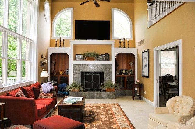 8030 Deershadow Ln, Montgomery, OH 45242 - living area with ceiling fan, a towering ceiling, and a fireplace with raised hearth
