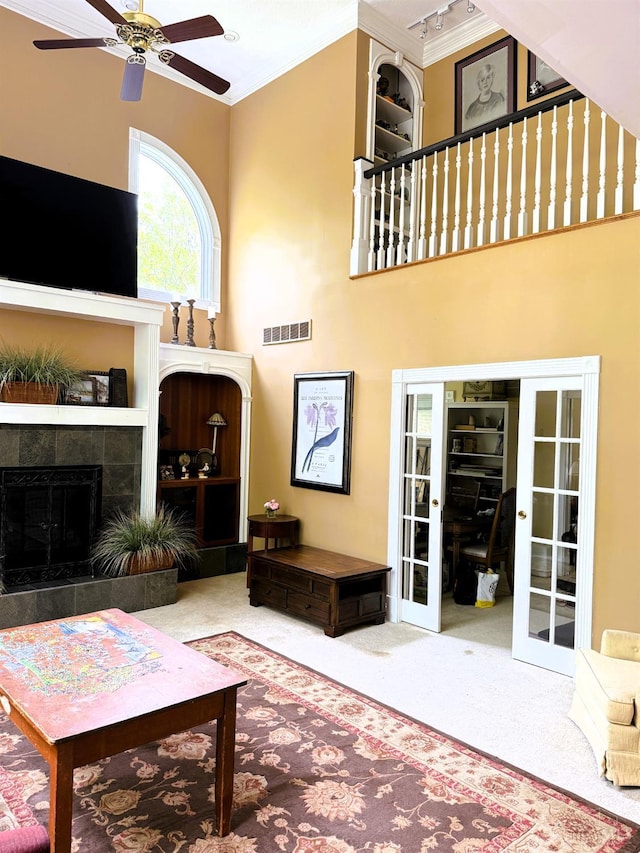 8030 Deershadow Ln, Montgomery, OH 45242 - living room with french doors, a ceiling fan, carpet floors, a tile fireplace, and crown molding