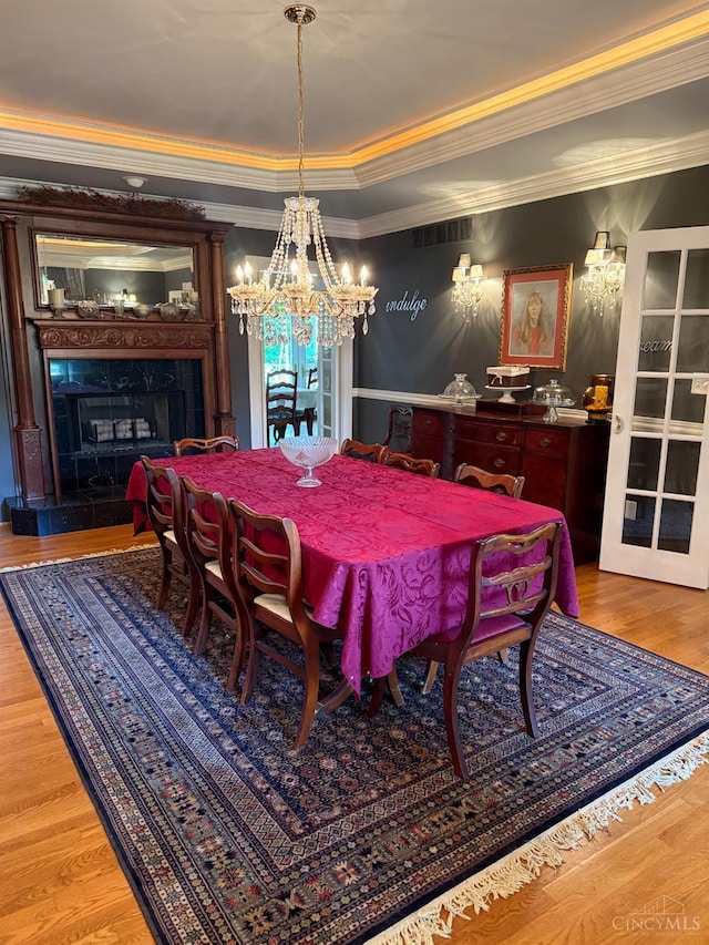 8030 Deershadow Ln, Montgomery, OH 45242 - dining space with ornamental molding, a chandelier, a premium fireplace, and wood finished floors