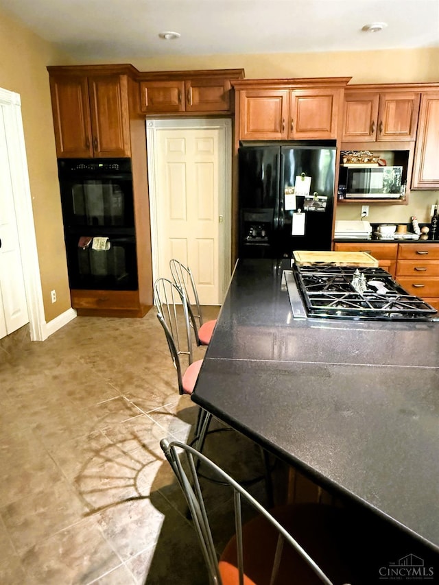 8030 Deershadow Ln, Montgomery, OH 45242 - kitchen featuring black appliances, dark countertops, brown cabinets, and recessed lighting