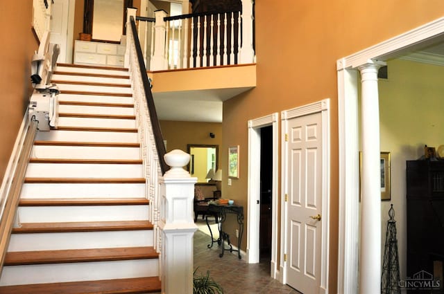 8030 Deershadow Ln, Montgomery, OH 45242 - stairs with tile patterned floors, a high ceiling, and decorative columns