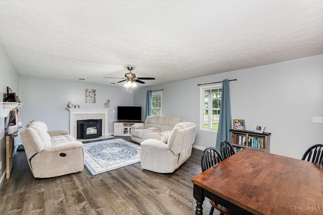 13726 New Harmony Shiloh Rd, Pike Twp, OH 45154 - living area featuring wood finished floors, a ceiling fan, a tiled fireplace, and a textured ceiling