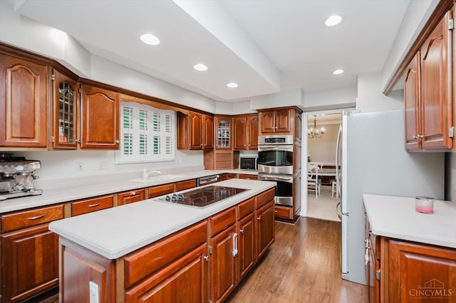 9930 Tall Oaks Ct, Deerfield Twp, OH 45140 - kitchen featuring stainless steel appliances, a kitchen island, wood finished floors, light countertops, and glass insert cabinets