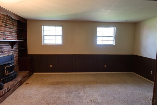704 Trafalgar Ct, Middletown, OH 45044 - unfurnished living room featuring a wood stove, wainscoting, carpet floors, and wood walls