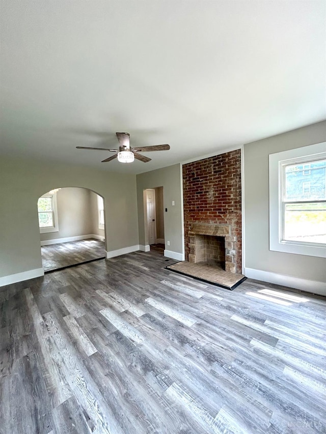 3501 Mcfarlan Rd, Cincinnati, OH 45211 - unfurnished living room featuring ceiling fan, wood finished floors, plenty of natural light, and arched walkways