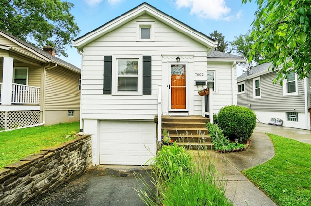 7002 Cambridge Ave, Columbia Twp, OH 45227 - shotgun-style home featuring an attached garage, a front yard, and asphalt driveway
