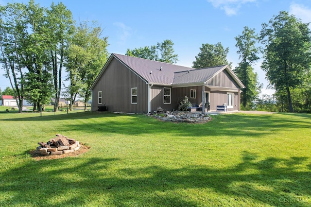 6226 Hunt Rd, Wayne Twp, OH 45118 - rear view of house with a fire pit, a lawn, a metal roof, a patio, and board and batten siding