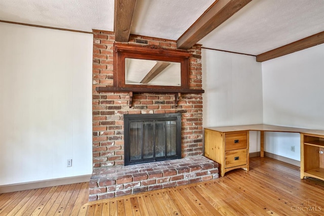 10730 Adventure Ln, Montgomery, OH 45242 - unfurnished living room with beam ceiling, hardwood / wood-style floors, a brick fireplace, a textured ceiling, and an office area