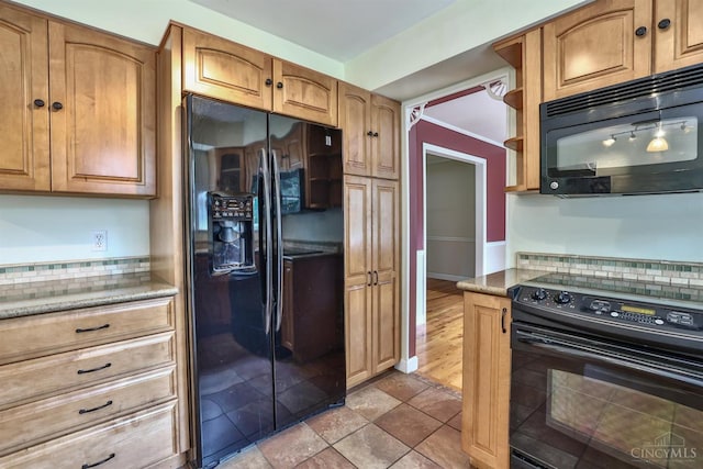 10730 Adventure Ln, Montgomery, OH 45242 - kitchen featuring black appliances, light stone countertops, brown cabinets, and backsplash