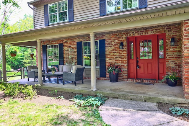 10730 Adventure Ln, Montgomery, OH 45242 - doorway to property featuring covered porch, brick siding, and an outdoor hangout area