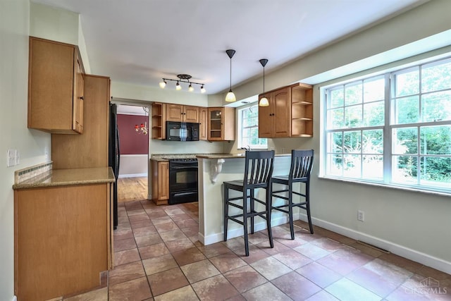 10730 Adventure Ln, Montgomery, OH 45242 - kitchen featuring open shelves, black appliances, a breakfast bar, a peninsula, and brown cabinetry
